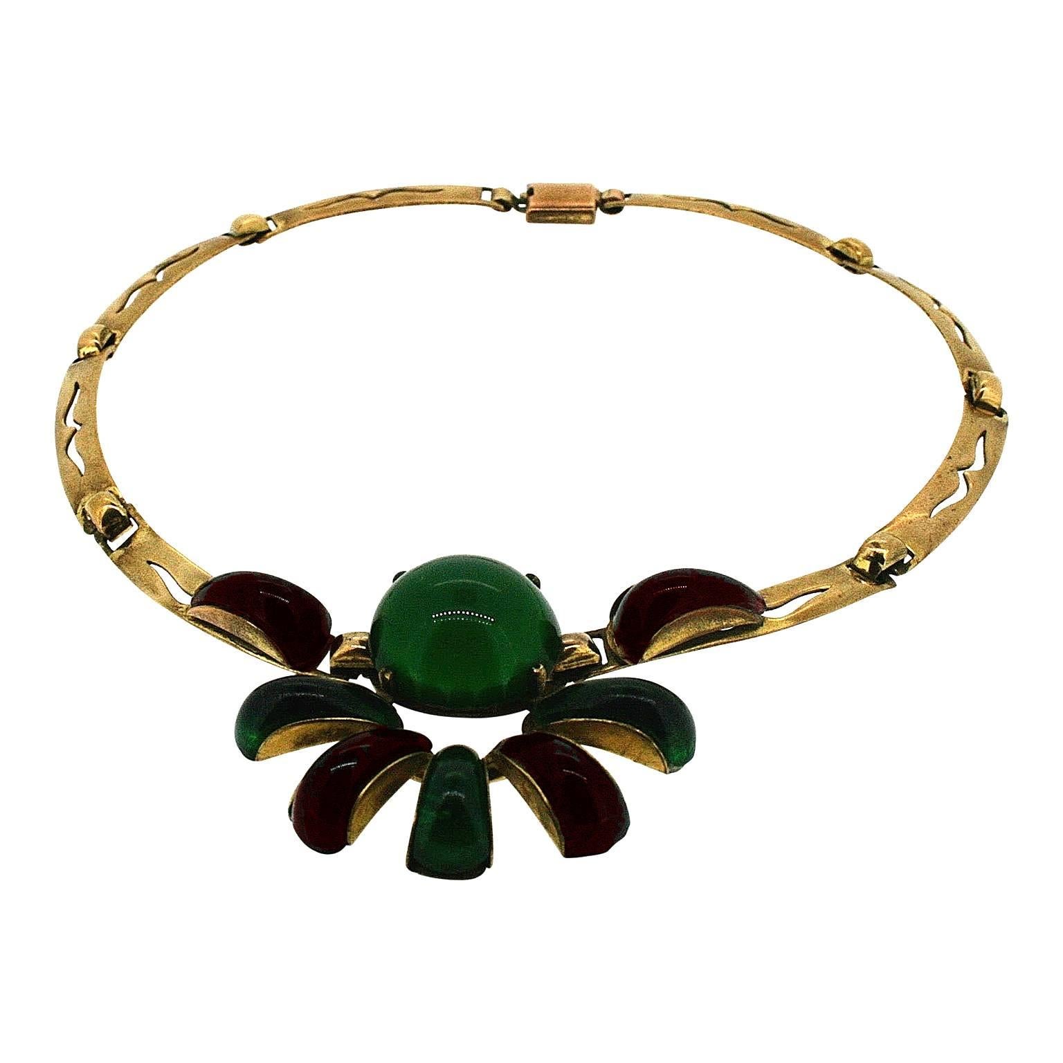 This wonderfully evocative necklace was created in France in the 1930s. It features highly collectible Gripoix glass and remarkable Machine Age design. 
Condition Report:
Very Good - A tiny chip to the edge of one green glass panel. This is only