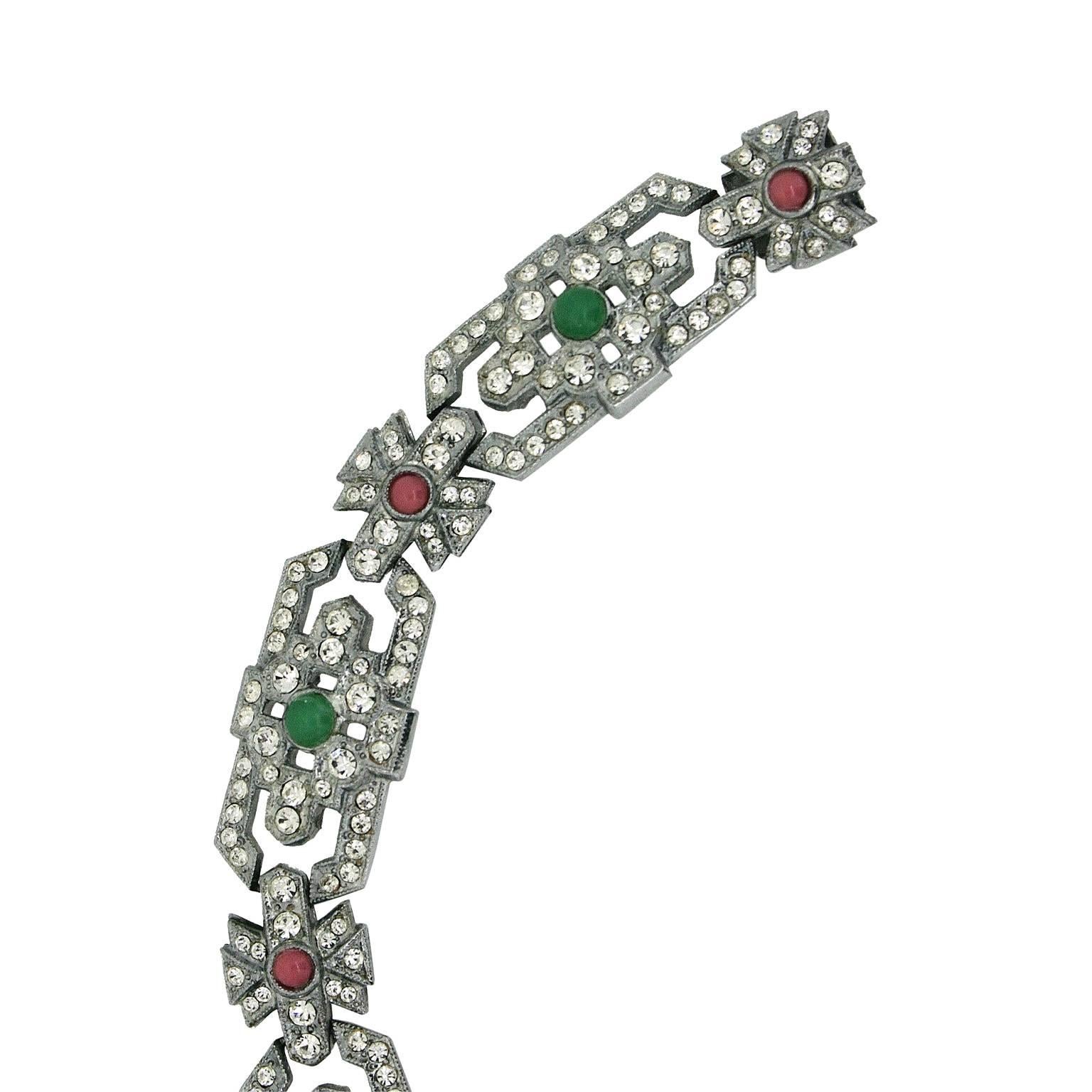 Shimmering and immaculate, this bracelet dates from the 1930s and is unsigned. 
Condition Report:
Excellent
The Details...
This silver tone bracelet features an Art Deco design encrusted with round faceted diamantes and detailed with pink and green