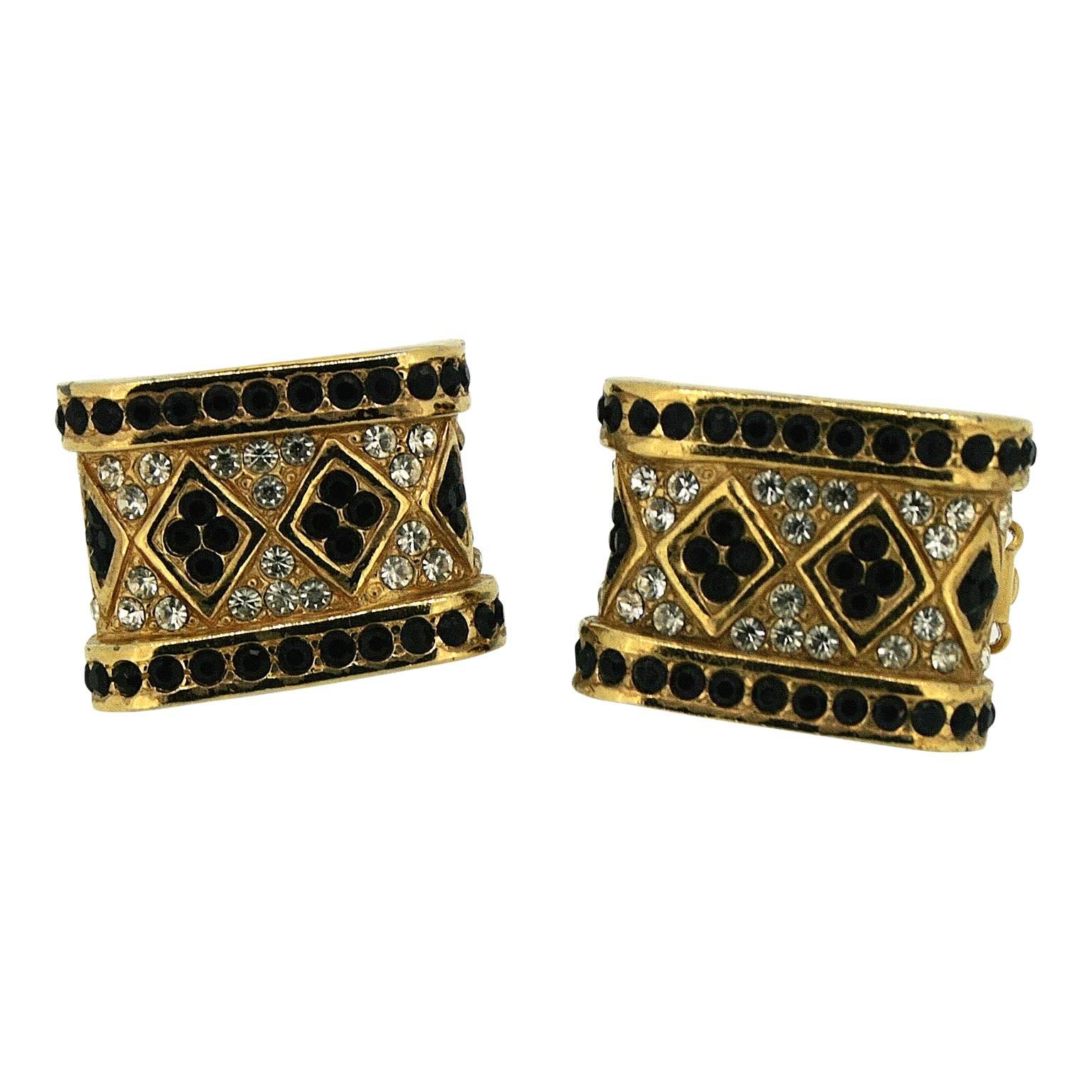 Featuring deep black rhinestones, these earrings date from the 1970s and were made by Ciner.
Condition Report:
Excellent
The Details...
These gold tone rectangular panel earrings feature a pattern comprised of small, round black and clear