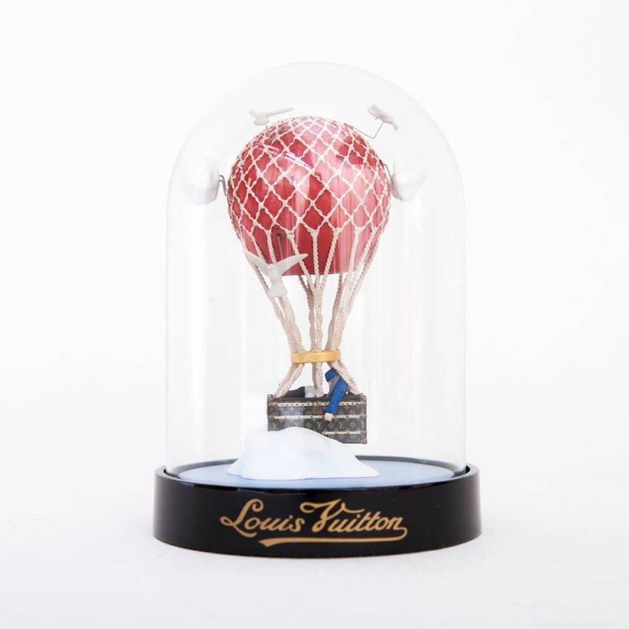Louis Vuitton Hot Air Balloon Snow Globe VIP. This is a limited 2013 Christmas edition. Reserved for VIP customers of Louis Vuitton. 

This features a hot air balloon with a Louis Vuitton trunk encased in a glass dome. 

Dimension: 8 x 8 x 12 cm.