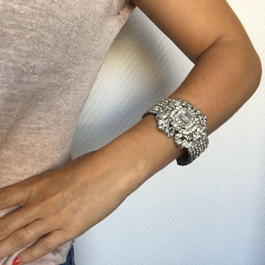 CHANEL couture cuff in silver plated metal and strass. The interior is in metallic gray, perforated. Brand mark present. Vintage bracelet.

In good condition. Small cracks on the inside (see photos). Small strass are disposed randomly (see photo)