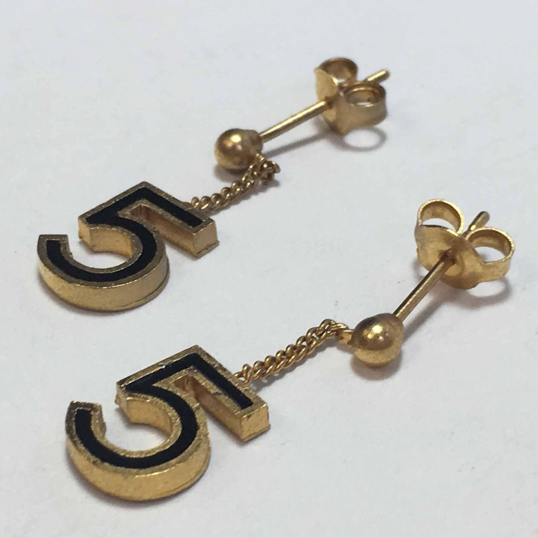 Chanel number 5 ear studs in gilt metal and black resin.

Delivered in a Valois Vintage Paris pouch.