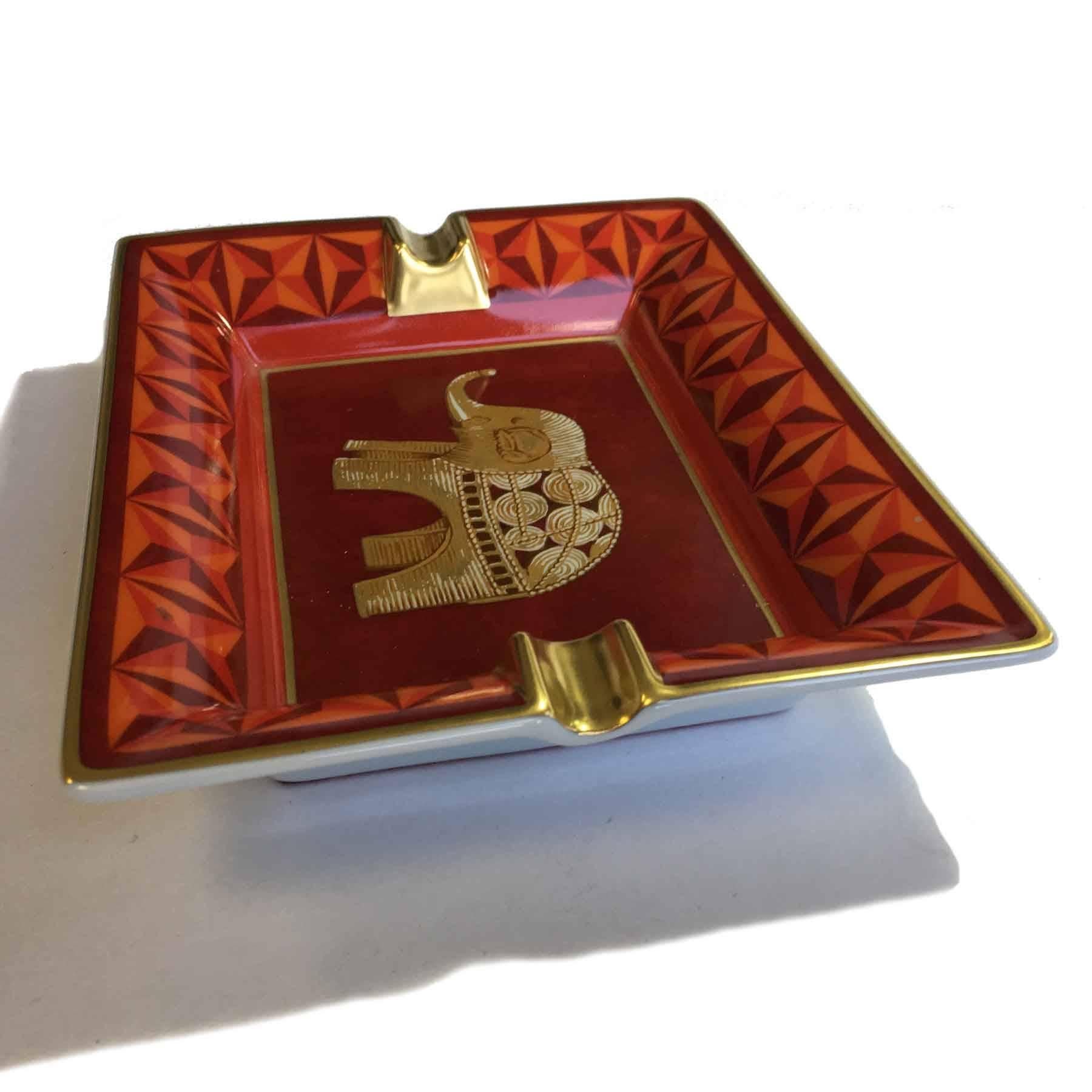 3H Hermes Ashtray decorated in Limoges orange porcelain. Motif: elephant. 
The underside of the Ashtray is sheathed with burgundy velvet goat, 3 H in gold color stamped in the middle.

Delivered in a Valois Vintage Paris pouch.