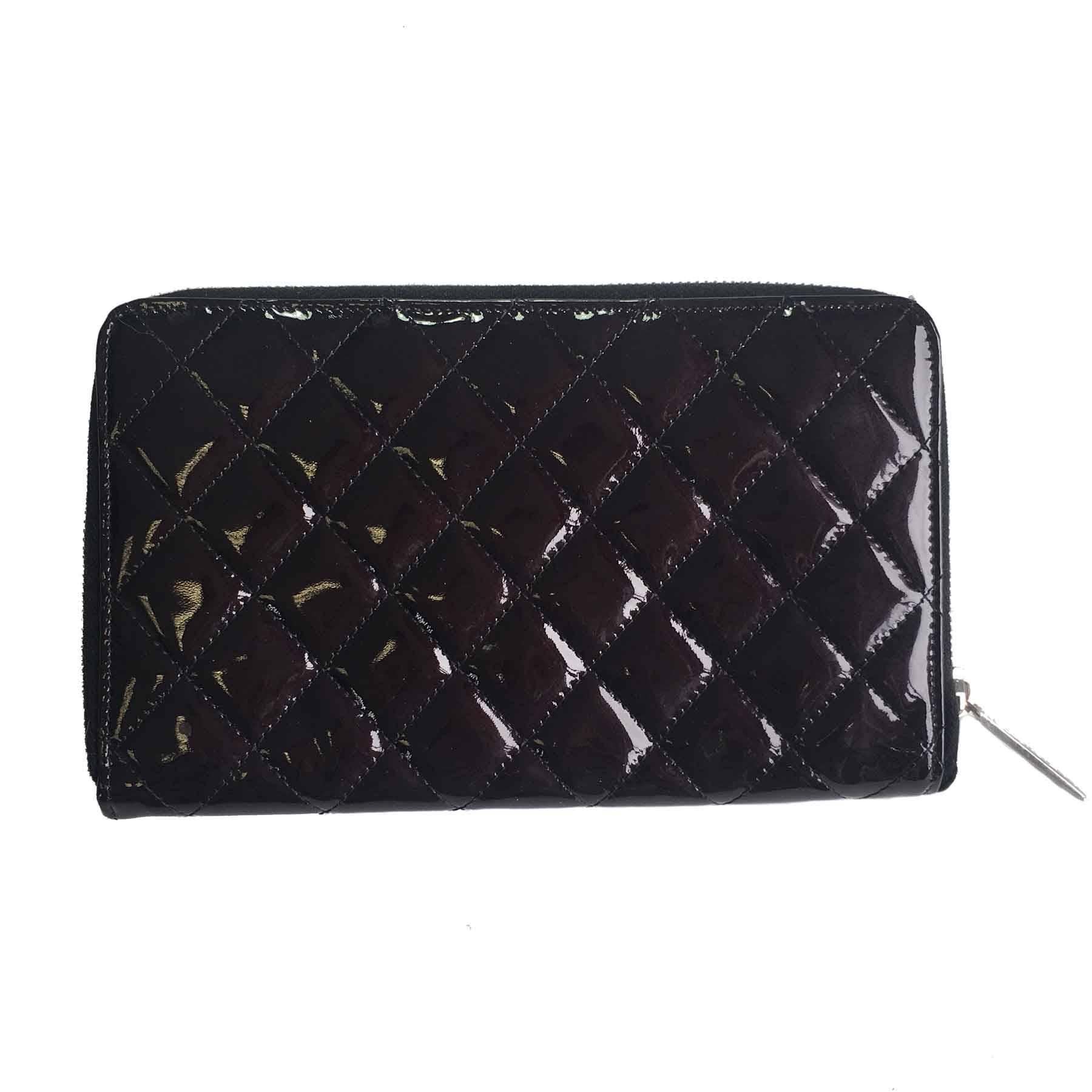 Chanel zipped wallet in quilted black patent leather. CC in silver plated metal. Black leather interior. S of the Private Sales inscribed inside a pocket.

Inside: 16 card slots, 4 bill slots and a zipped pocket.

Delivered in a dust bag Valois