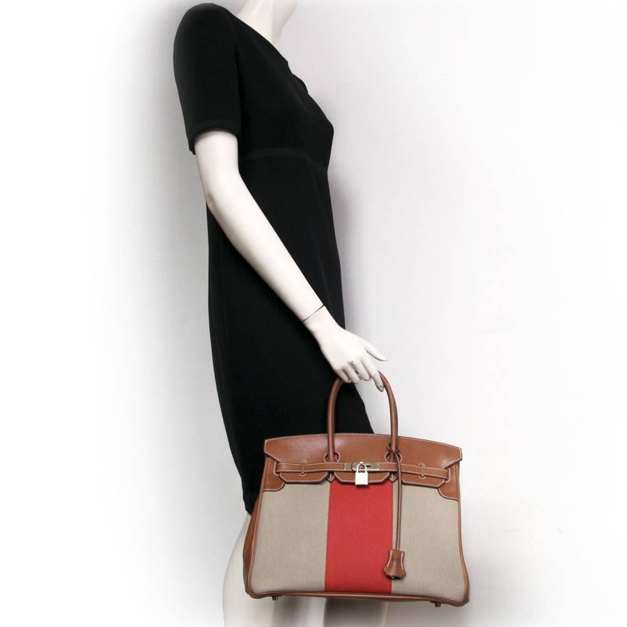 Bag 'birkin 35 flag' from the Hermès House, beige H canvas with an orange center band and calf leather barenia, saddle stitching. 
Stamped R in a square. 
The hardware is in gilt metal. The interior is in brown leather with two pockets, one