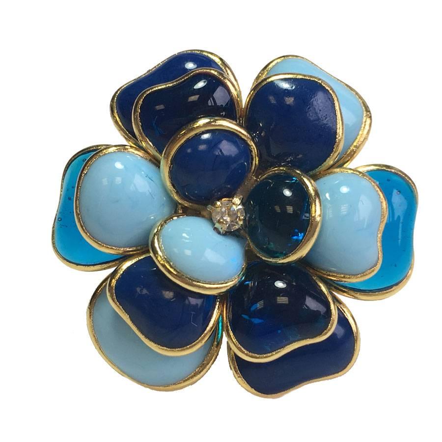 Marguerite de Valois camellia ring in blue molten paste (light, navy), small rhinestone in the heart of the camellia. 
Gilt metal with fine gold. 

French manufacture in the workshops of the Maison Marguerite de Valois whose jeweler craftsmen have