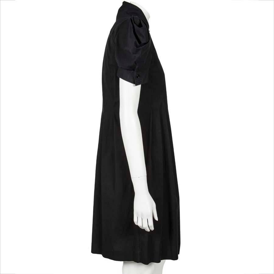 Alexander McQueen dress in black cotton. Straight cut, pleated at front and back, marine collar, composed of a pocket on the left of the chest.
Closes with a row of buttons.

Dimensions flat:
Extent 78 cm, length of sleeves 20 cm, arm circumference