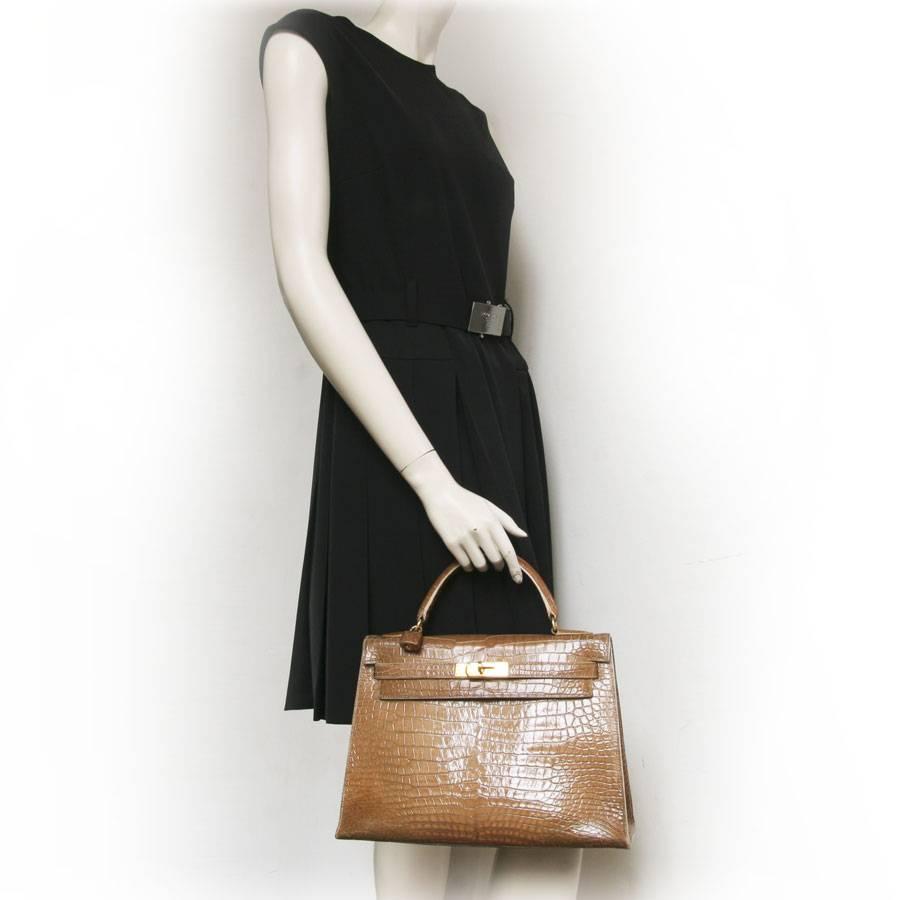 Hermès Kelly 32 bag in shiny light brown crocodile porosus leather with gilt metal hardware.
Inside, two flat pockets and a large zip pocket.

It is worn by hand using a handle that measures 25 cm. There is a padlock in the same skin (missing the