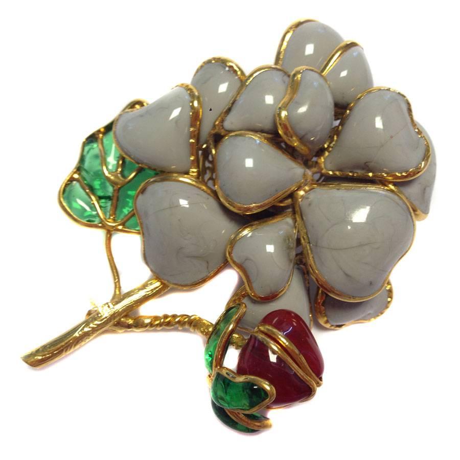 Magnificent brooch couture Marguerite de Valois made in 2007. 
Frame in gold plated metal with fine gold, large flower in gray molten glass, leaf in emerald green molten glass, flower in ruby color molten glass.

The Maison Marguerite de Valois