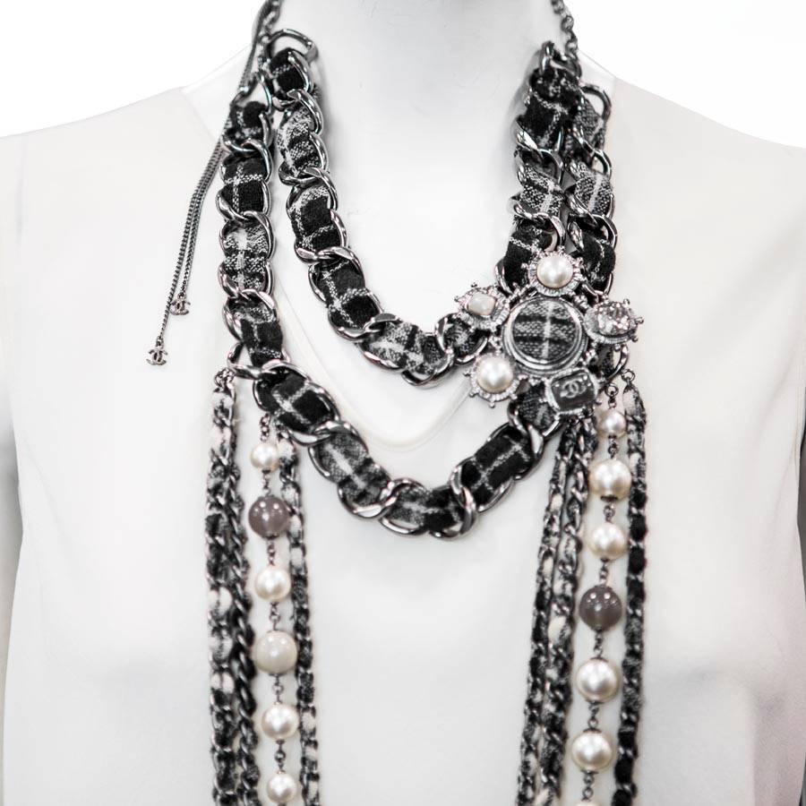 Imposing Chanel chain necklace from Les Métiers d'Art 'Paris-Edinburgh' multi rows in black, smoky gray and beige tweed, a row of nacreous and smoky gray glass pearls . 
On the side it has an important aged silver metal jewelry in tweed, pearls,