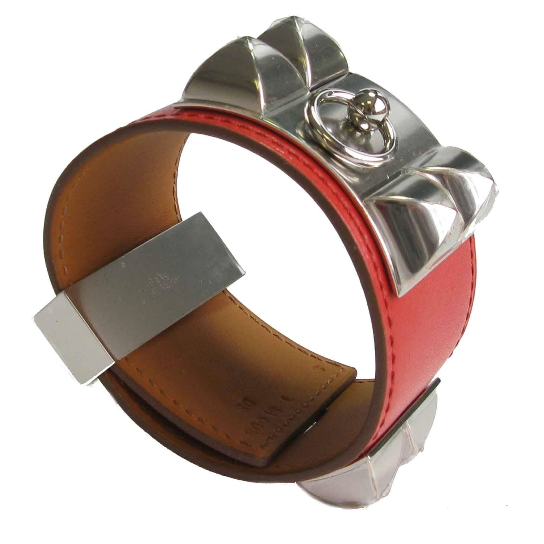 
Hermes  Collier de Chien CDC Cuff Bracelet in calf leather tadelakt sanguine color, fittings in palladium silver.

Letter T, year 2015.

Dimensions:  from the clasp to the first hole 16 cm, in the middle 18 cm, the last hole 19 cm.

Delivered in a