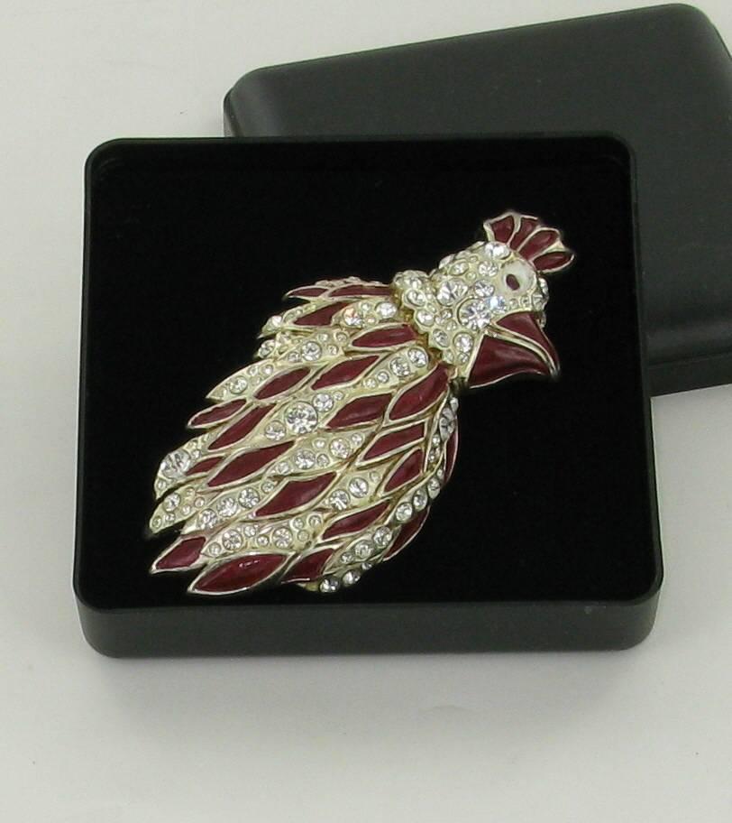 Very nice NINA RICCI brooch representing a parrot with burgundy feathers, set with Swarovski rhinestones. This piece is vintage which explains why the metal is slightly blackened. 

It closes with a secured pin.

Delivered in a protective box.