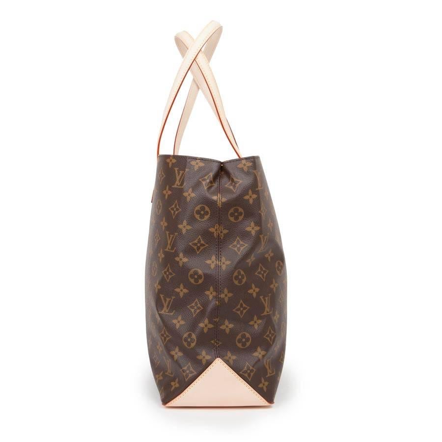 Louis Vuitton 'Wilshire' handbag in monogram brown canvas. Gold plated hardware. Brown suede interior with two plated slits and a zipped pocket.
Closes with a small carabiner. Nails under the bag. 

Worn hand or shoulder with two handles in light