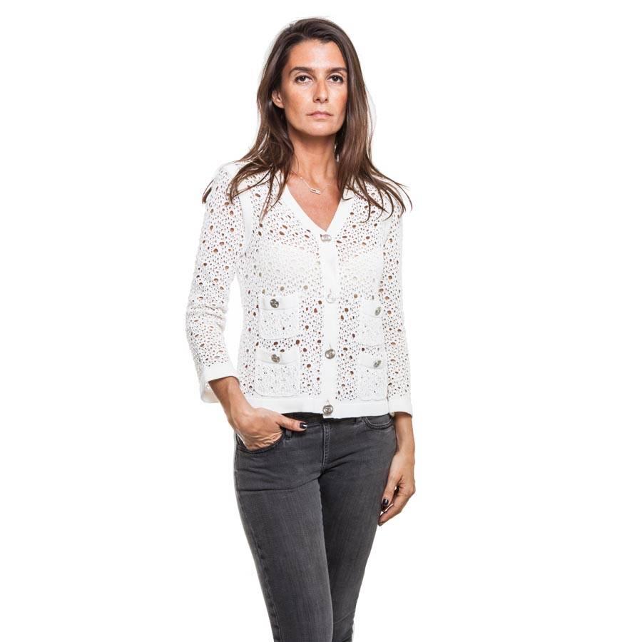 CHANEL cardigan in white cotton lace mesh and polyamide. It closes with 4 metallized buttons 'CC'. It has 4 front pockets.

Dimensions flat: shoulder width 36 cm, length of sleeves 54 cm, wrist circumference 26 cm, bottom width 46 cm.

Delivered in
