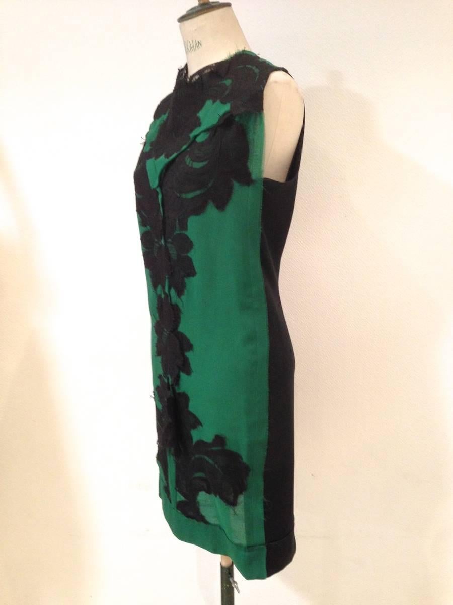 Vestido de cóctel LANVIN sin mangas de seda duchesse negra en la espalda, donde se perfila una larga cremallera de 87 cm. La parte delantera es de seda verde sobre la que se ha concebido un sublime encaje negro en toda su longitud.

Es una pieza de