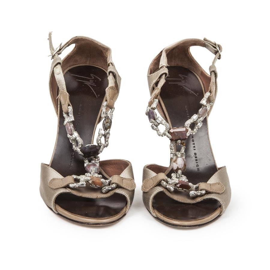 Giuseppe Zanotti Heel opened sandals in beige satin, set at the front by Swarovski crystals and multicolored stones.

The heel is in dark brown wood.

Public price 865 euros.

Dimensions: insole length 24 cm