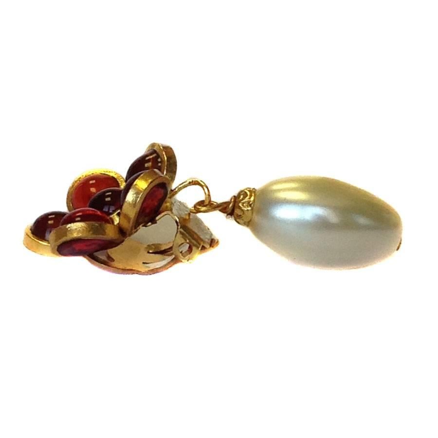 Marguerite de Valois flower clip-on earrings, in ruby molten glass and oval glass pearl. Gilded metal with fine gold.

Made in France, by craftsmen of the MARGUERITE DE VALOIS brand, who have made jewelry in the past (more than 40 years), for the