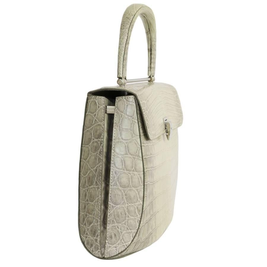 Sac en crocodile vert d'eau et marron clair de la Maison Asprey de Londres.

Matériel en métal palladium. L'intérieur est en daim clair avec 4 poches plaquées dont une zippée. 

Série spéciale pour les VIP. Victoria Beckham (voir photo).

Sera livré