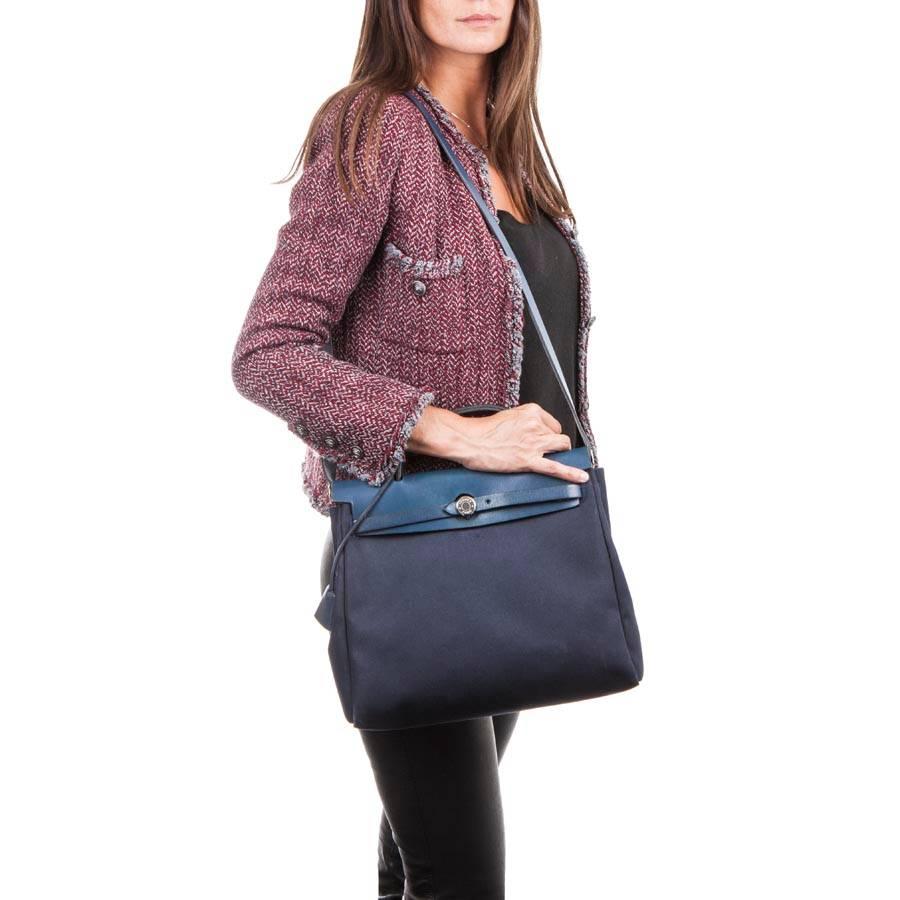 HERMES Herbag bag in canvas and dark blue leather. It has a silver plated hardware. 
Hand-worn with the handle or on the shoulder with the shoulder strap: 100 cm.
Included : tirette, keys, cadena and clochette. It has an extra pocket in natural