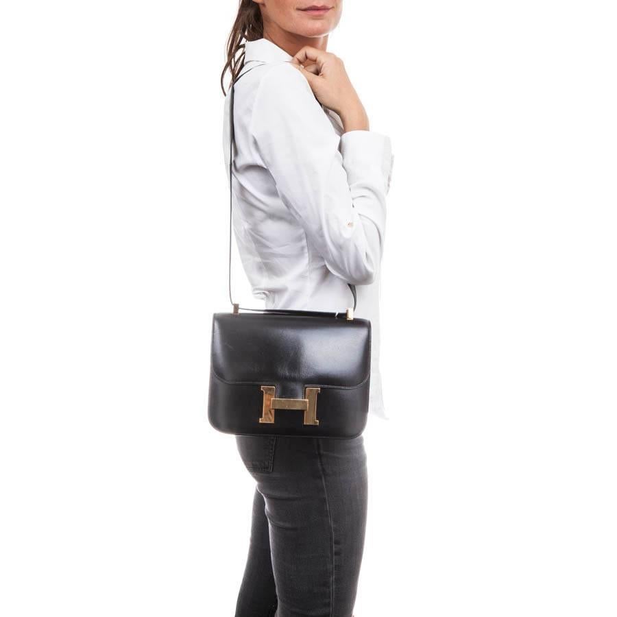 Vintage! 'Constance' Hermes flap bag in black box leather. Gilded brass hardware (micro scratches). 

It has a flap and is worn on the shoulder or crossover with adjustable handle: 100 cm. It has an outer slot at the back.

The interior is in black