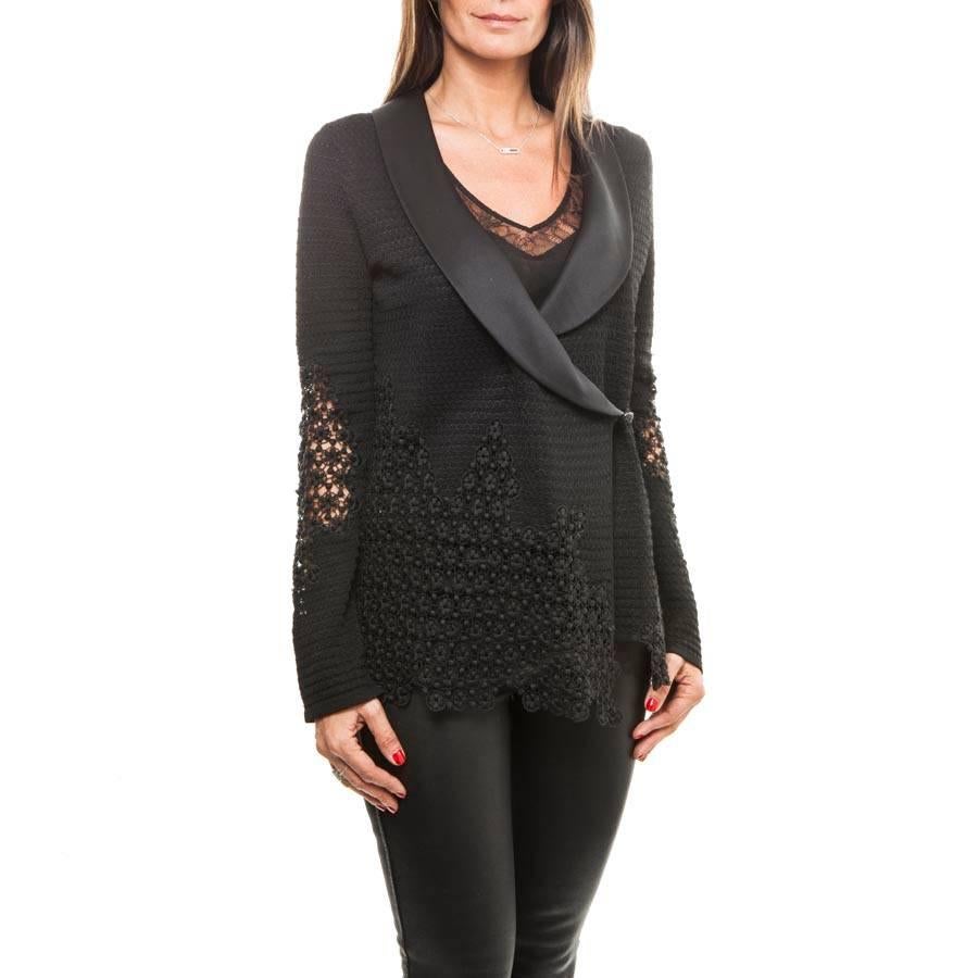 Chanel jacket in viscose and cotton, embroidered with black lace. Closes with two buttons. 
The collar is in satin. 

Dimensions: shoulder width 40 cm, length of sleeves 68 cm, Wrist circumference 22 cm, bottom width 43.5 cm