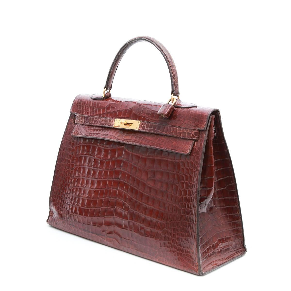 Hermes 'Kelly' 35 handbag in brown semi matt crocodile porosus with padlock. No zipper, keys or clochette. 

Stamp O (1959). Gold-plated hardware with micro scratches. The interior is in smooth brown leather with 3 pockets including a zipper.

Will
