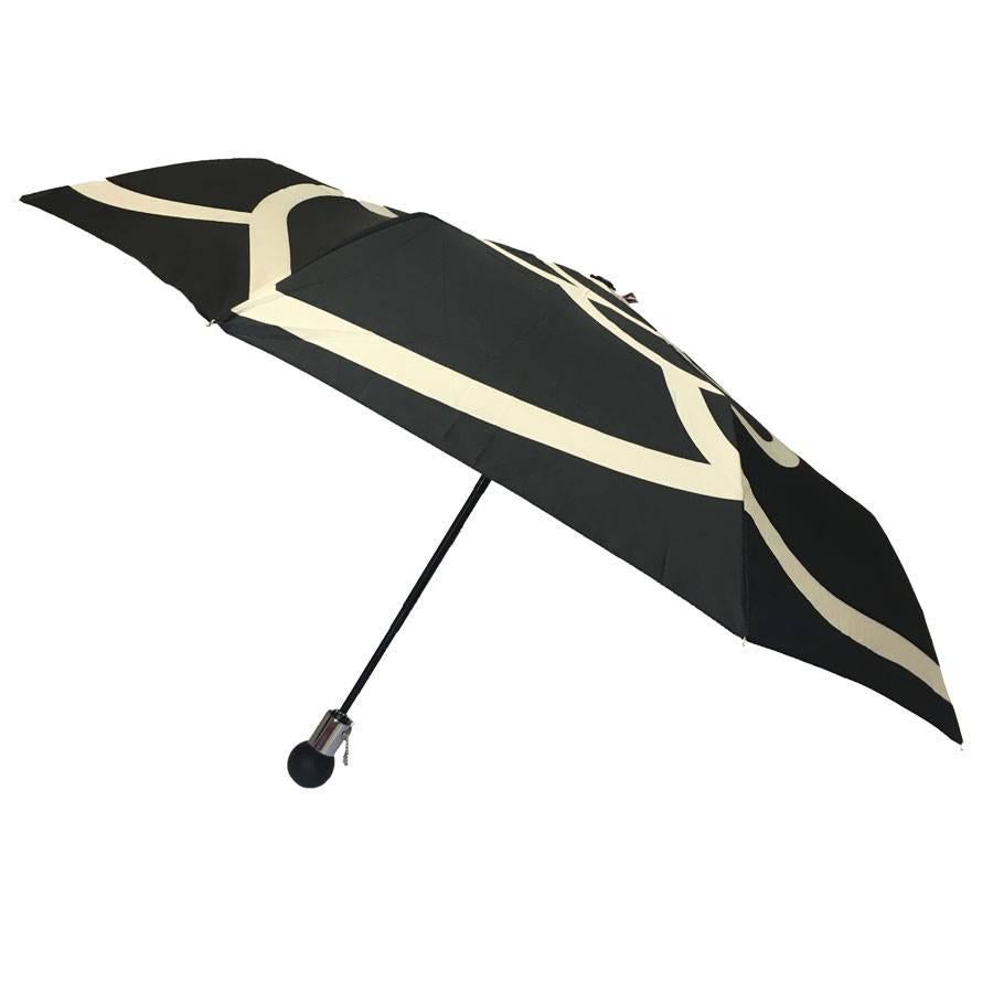 Black and white Chanel Umbrella. Drawing of a white camellia on a black background when it is open.

100% polyester.

Brand labels and material inside.

Delivered with its protective cover, all in a bag of quilted fabric with its chain