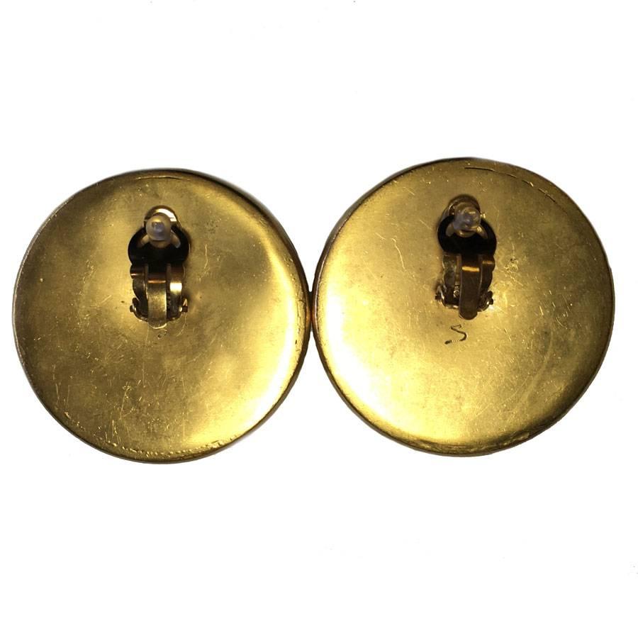 Very rare! Collector CHANEL huge round clip-on earrings in golden metal. CC in the center. Stamp of the present brand. Correct state.

S from the private Chanel sales engraved on each buckle on the back.

Weight of a loop: 47 grams

Delivered in a