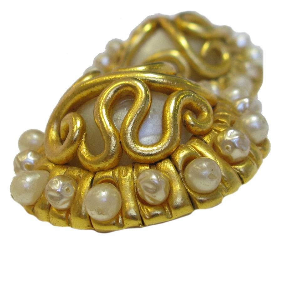 Couture! Imponenti orecchini tondi Chanel in metallo placcato oro, pezzo perlato al centro e incastonato con piccole perle sul giro.

In buone condizioni. Gioielli vintage.
Timbro Chanel sul retro.

Dimensioni: 4,7 cm di diametro

Consegnato in un
