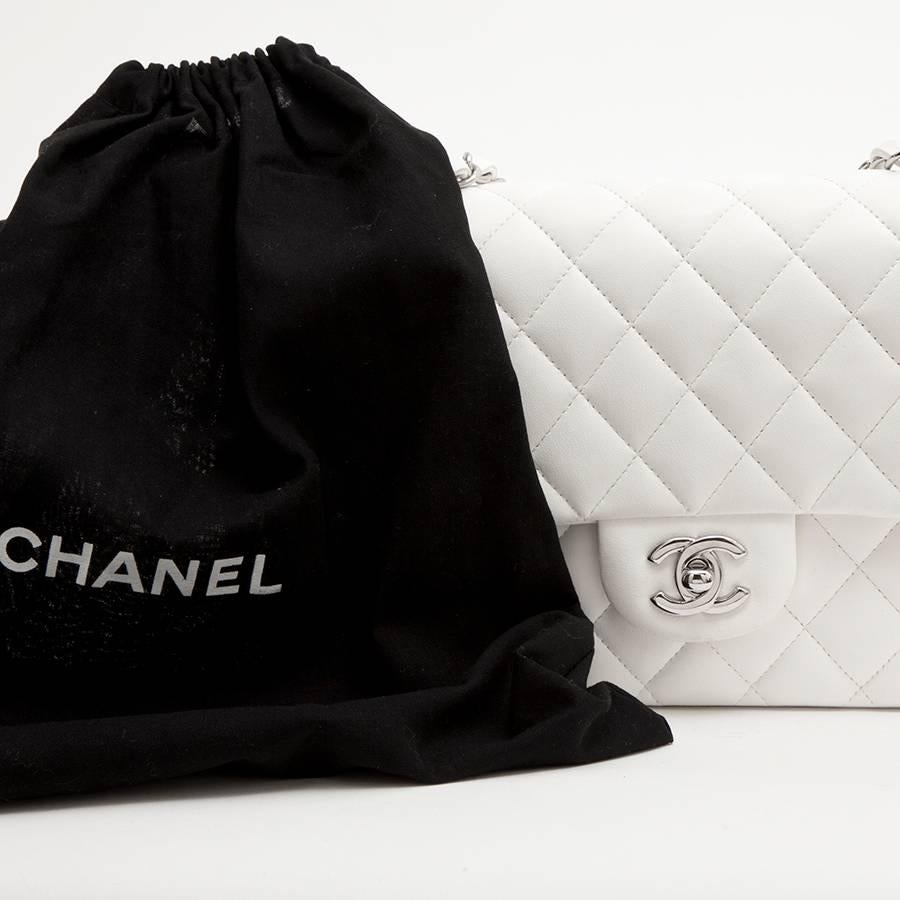 Chanel Timeless double flap bag in quilted white lamb leather. Palladium silver hardware. 
It is worn shoulders or crossover: 89 cm at the longest. 

It has a double flap with a mini zip pocket, an outer slit and a 'CC' clasp.

The interior is