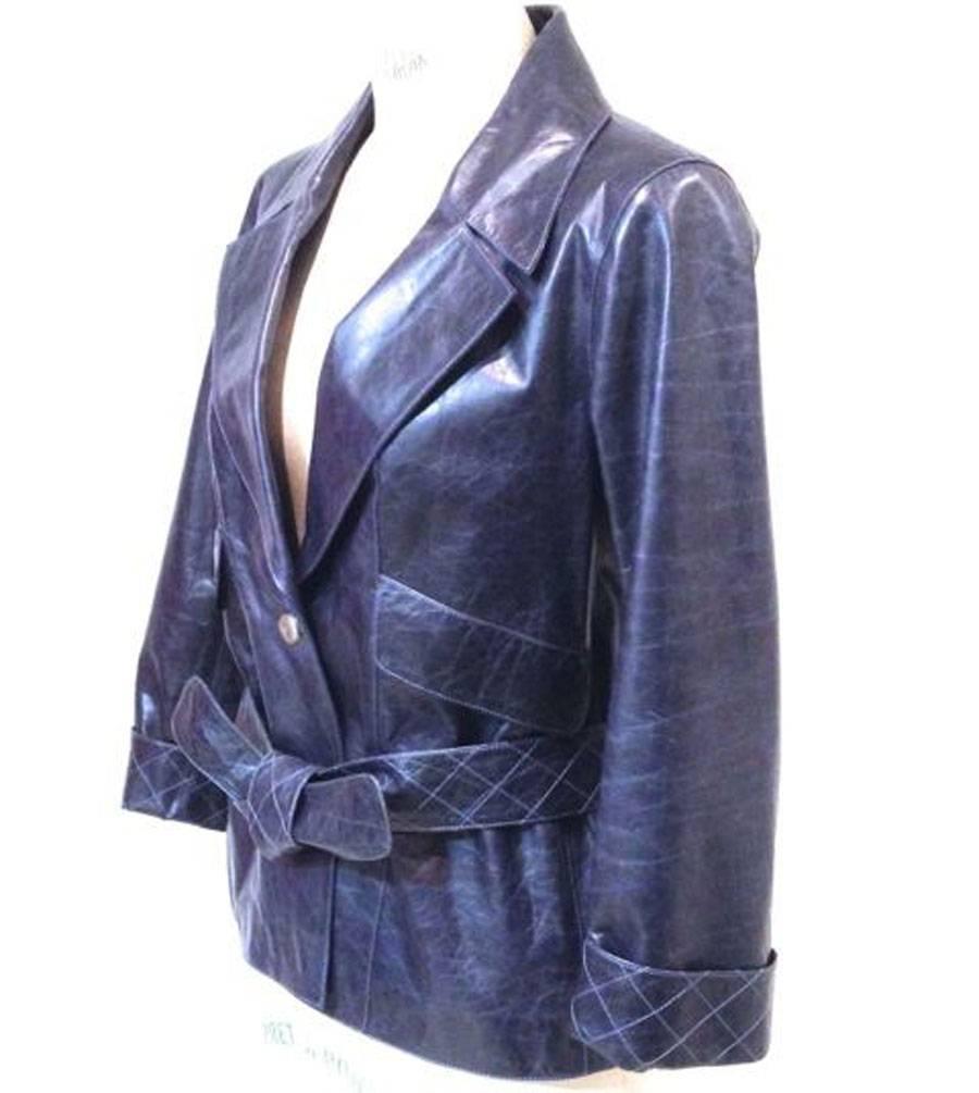 CHANEL jacket in faded blue calf leather. The sleeves have a nice quilted lapel. Two large flap pockets. Quilted belt with belt loops on the back. Interior lining in black and blue printed silk.

 A nice button in silver plated silver CC is used to