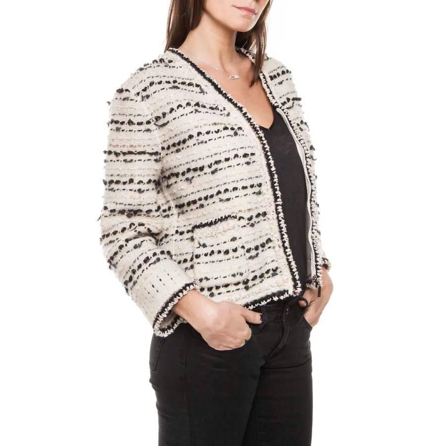 Chanel Vest style zip-up jacket in beige-colored and black wool and cashmere, beige ribbons and orange sequins.  A aged silver chain is along the bottom of the waistcoat.

Fall 2005 collection.

dimensions flat: shoulder 45 cm, sleeve length three