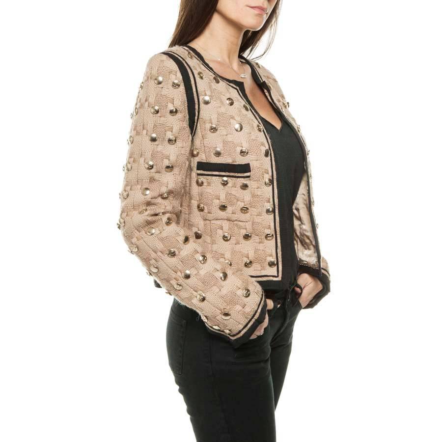 Collector! Chanel short jacket in beige wool lined with black bands, fully studded (buttons) with CC, neutral and matte gold color. The lining is 100% monogram silk. The bottom ends with a golden chain. There are two pockets.

Dimensions flat: