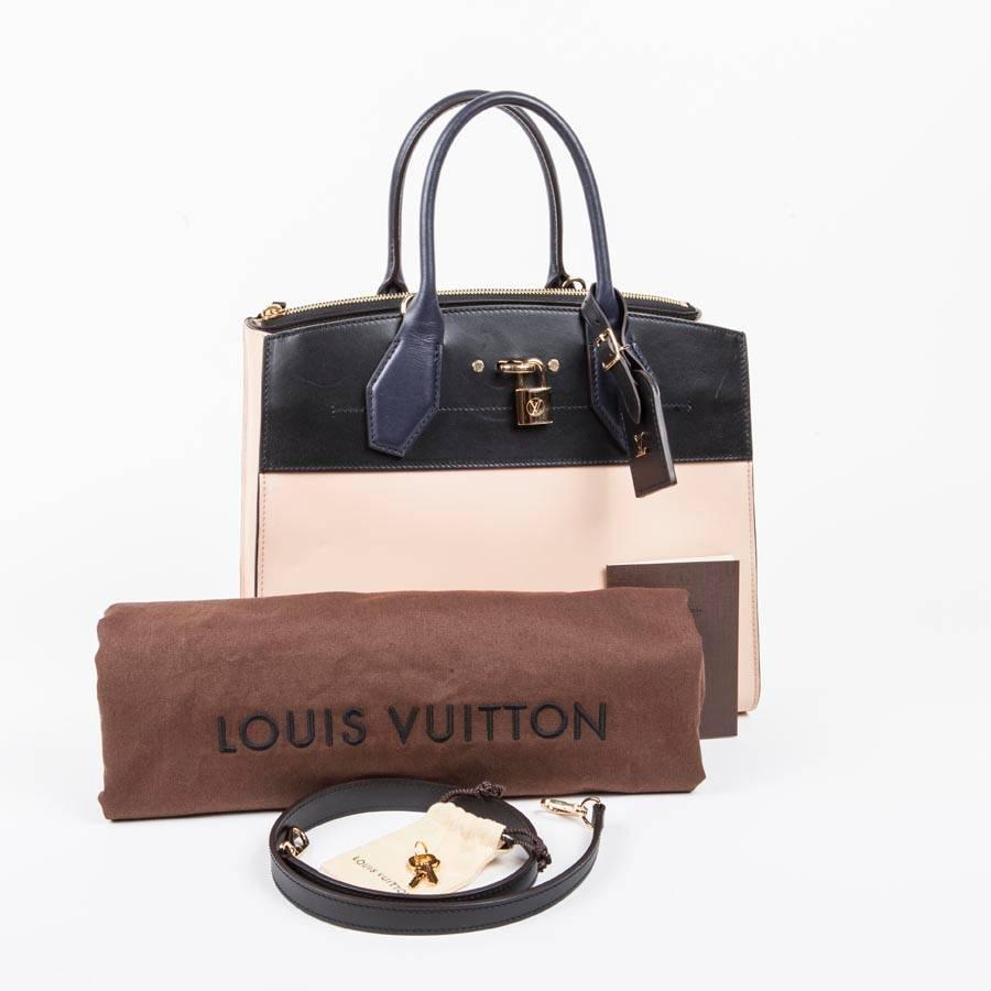 Louis Vuitton bag 'City steamer MM'  in tricolor beige and navy blue and black, smooth leather. Gilded metal parts. LV metal lettering address holder. Engraved padlock. Signature LV rim marked hot on the back. 
Removable shoulder strap in 65 cm