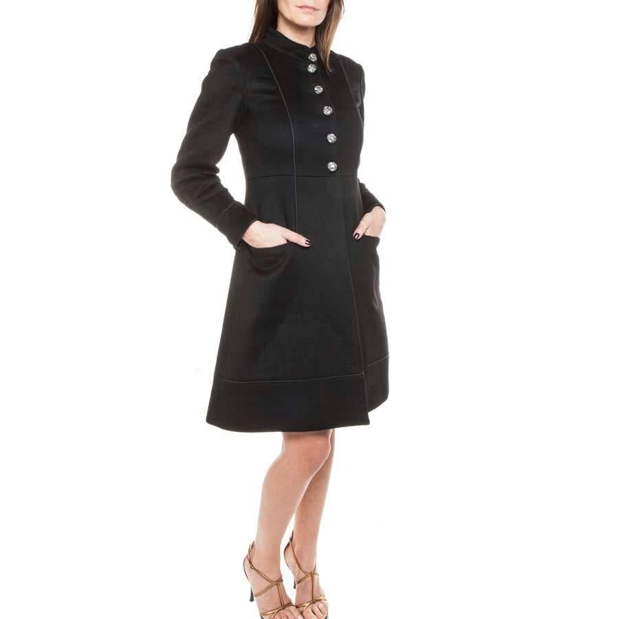 Chanel 'Paris-Moscou'coat in black cashmere closed by 6 black and silver buttons with the emblem of Russia. It has a martingale in the back marking a few folds at the waist. (an additional button). 
it is lined with black silk. There are 2 pockets