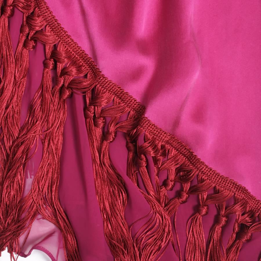 Rare! Cocktail dress JOHN GALLIANO in dark fuchsia silk satin with fine straps.

It is gathered in the middle of the chest with applications of embroidery of colored threads and fine pearls.

It is lined with a row of fringes in passementerie and a