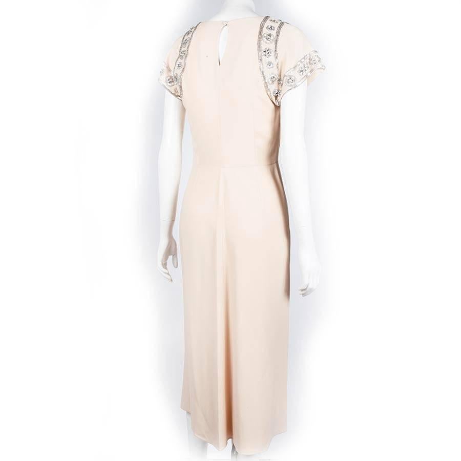 Christian Dior cocktail dress in beige silk crepe cut at an angle, embroidered with silver tubes and Swarovski crystals on the shoulders.

Slightly draped on the neckline with a flying band on the front.

Zipper on the left side.

Dimensions: