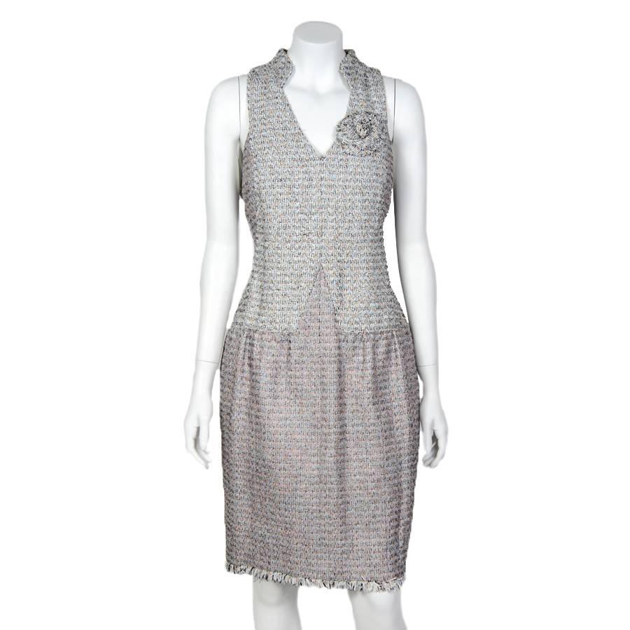 Beautiful Chanel dress in pastel colors tweed. The lining is made of silk. Zip closure in the back. A camellia-shaped brooch is attached at the level of the heart which dresses and distinguishes the dress.

The top of the dress is slightly lighter