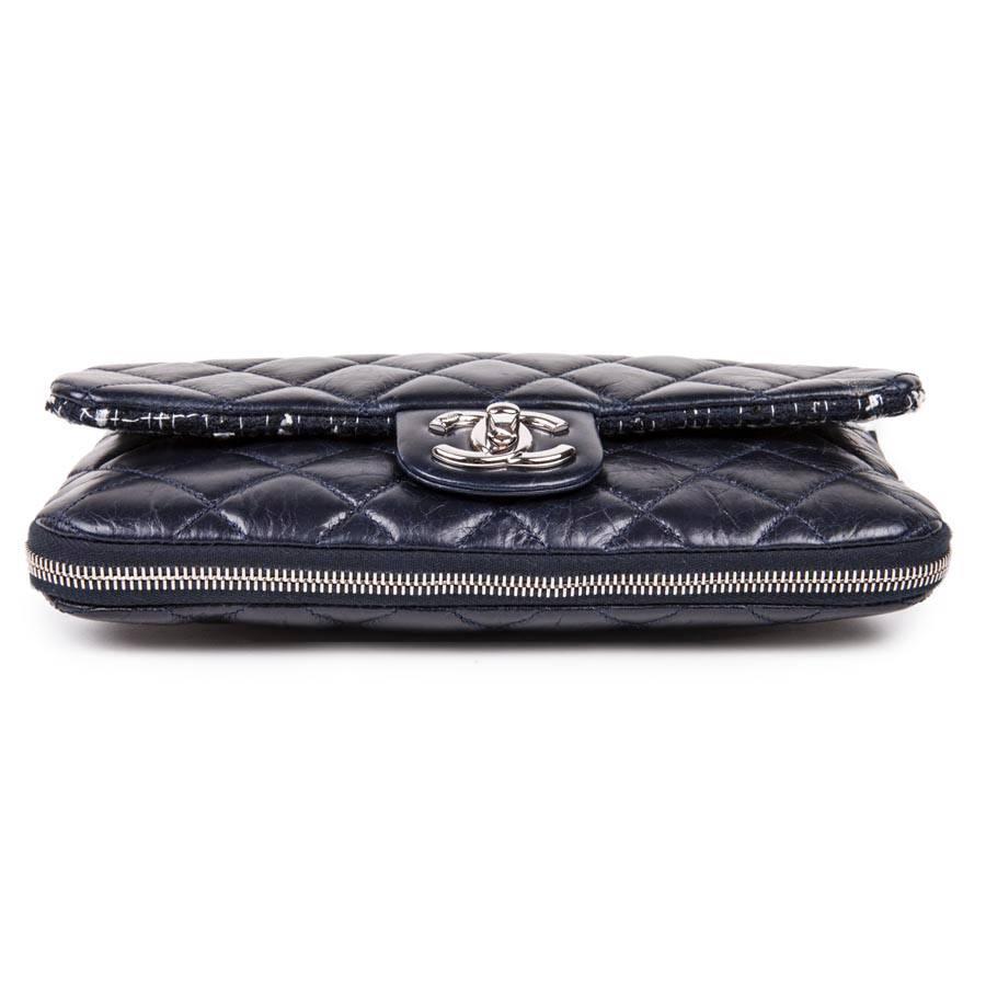 Chanel flap bag in bi-material navy blue tweed and quilted leather. Silver plated metal hardware. Clasp 'CC'. 
The inside of the flap is in tweed, the inside of the bag is in navy blue fabric with a zipped pocket. A zipper closure makes it possible