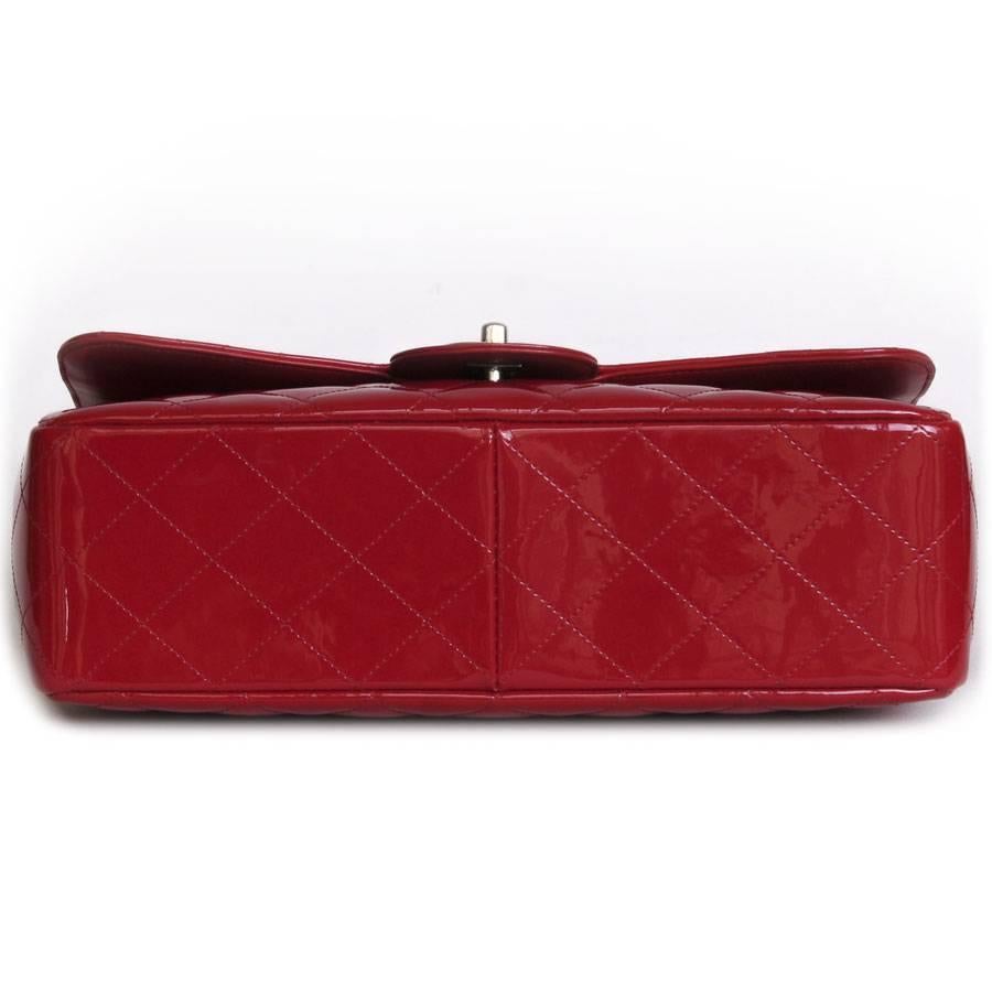 Gorgeous Chanel 'Jumbo' flap bag in red patent leather. The hardware is made of silver plated metal. Clasp 'CC'. 

It is worn on the shoulder with a metal and leather chain. 

The inside is in smooth leather with two pockets, one zipped. 
Included :