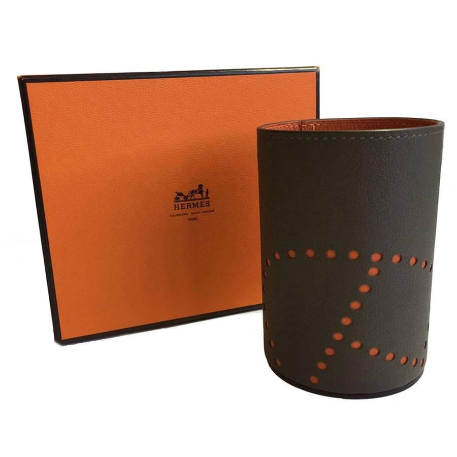 Hermes pencil case, 'Evelyn model' in étoupe and pumpkin smooth taurillon leather.

HERMES PARIS engraved on the bottom of the pot.

Delivered in its HERMES box

For your information retail price : 630,00 €