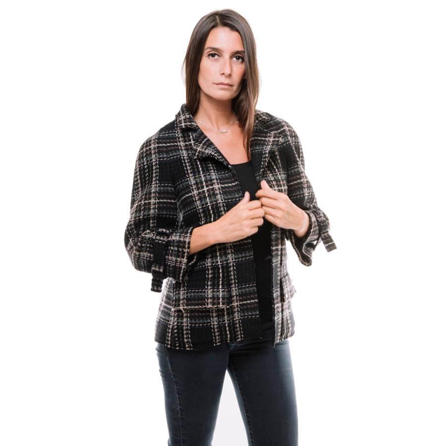 Chanel checked jacket in black wool tweed with beige, brown and purple checks and raglan sleeves.

It has 4 welt pockets on the front. Cut edges straight. The lining is in black silk with Chanel siglée.

Dimensions flat: width low 50 cm, length