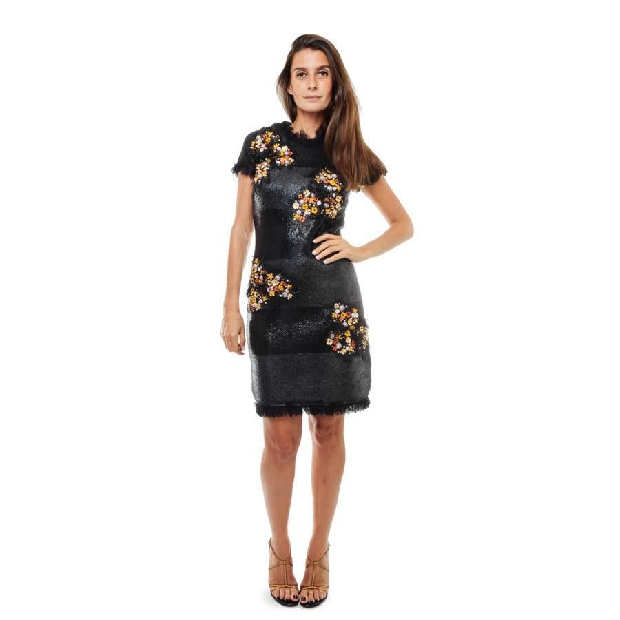 Chanel 'Paris Monaco' collection black embroidered dress in wool and silk.

The dress is black laced and embroidered with orange and gold flowers on the front. Sleeves are short and there are small tulle fringes around the collar, the sleeves as
