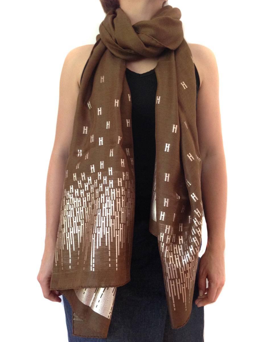 HERMES brown, gold with silver threads Stole in silk and cashmere
On each side of the stole there is a strip of gold and silver threads representing the H of the house HERMES.

Composition: silk, cashmere and polyester.  
It comes from press