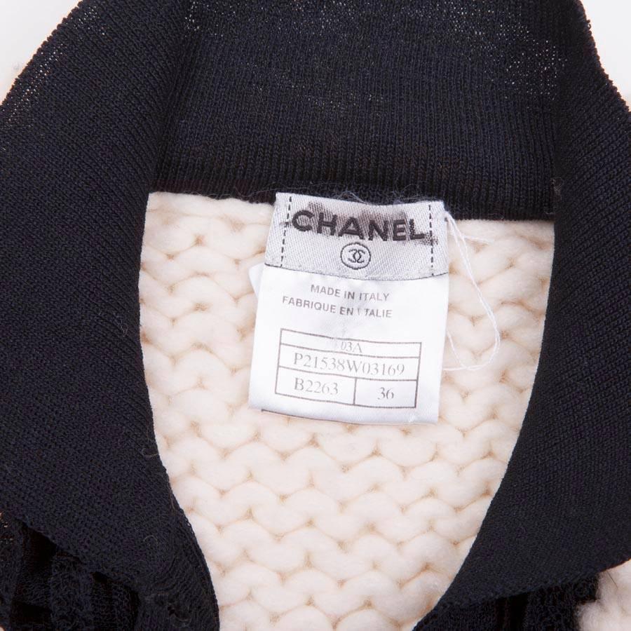 CHANEL knitted waistcoat in unbleached wool with a black front plastron. It closes at the front with 6 buttons marked 'CC' black. 
Fall 2003 collection.

Dimensions: shoulder width: 36 cm, length of sleeves: 75 cm, wrist circumference: 26 cm, bottom