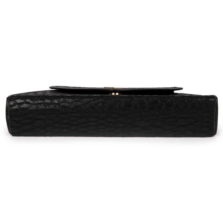 Revillon small evening bag in black silk with crocodile pattern. The Interior is lined with monogram fabric and has a zipped pocket. 

Included : It has its authenticity card. 

It is worn as a clutch or on the shoulder or crossed by a pretty gold