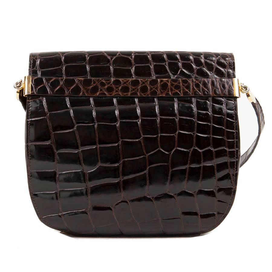 Christian Dior shoulder bag in brown crocodile leather and gilded hardware.
It closes with a snap button. 

Worn on shoulder. Length of the handle: 72 cm.

Will be delivered in its DIOR dustbag