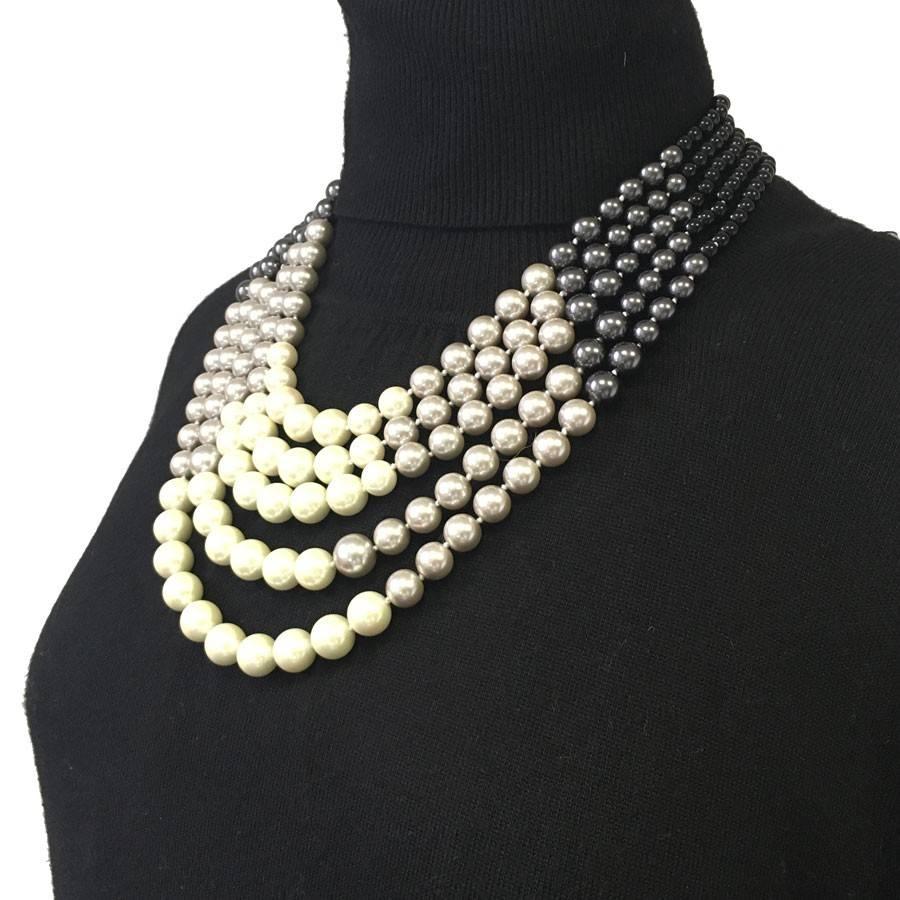 Sumptuous Chanel necklace 5 rows of pearls of 4 colors: beige, gray, anthracite and black. A beautiful gilded metal chain finishes this necklace. Hologram of the brand on the clasp. 

Dimensions:  length at the first ring: 48,5 cm - at the last