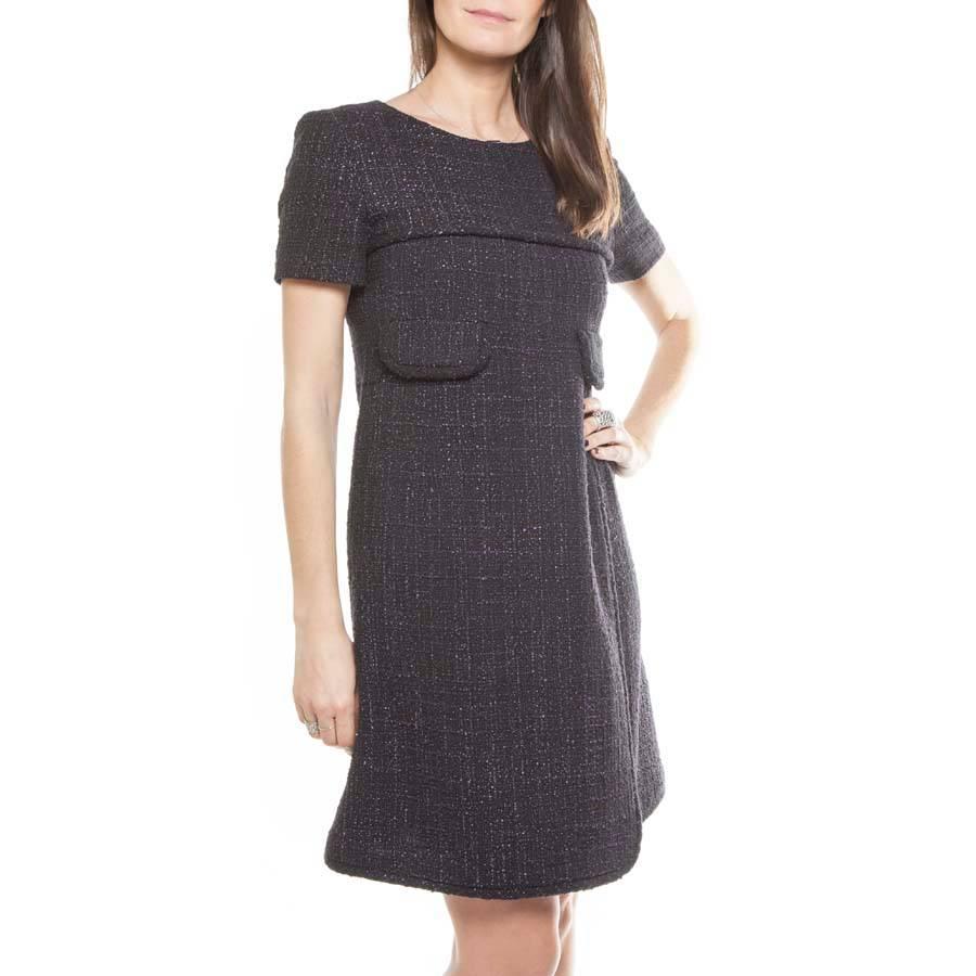 Chanel wrap dress in black and purple tweed (cotton), with two shallow pockets above the waist. It is lined with monogram silk. It is rolled above the chest, on the flaps of the pockets and on the hem.

Dimensions flat: shoulder width 38 cm,  sleeve