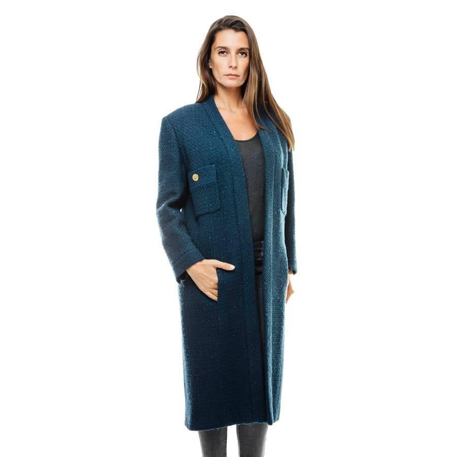 CHANEL straight cut coat in blue wool. 

It is composed of two front pockets closed by gold Chanel coco buttons. The same buttons adorn the cuffs in a row of three. chronogram CC silk lining. The coat does not close in its length.

Dimensions flat: